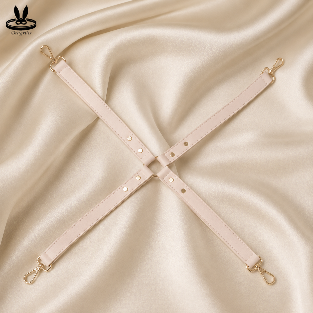 Adjustable blush pink four-point restraint connector strap system with gold-tone clips and central attachment ring.